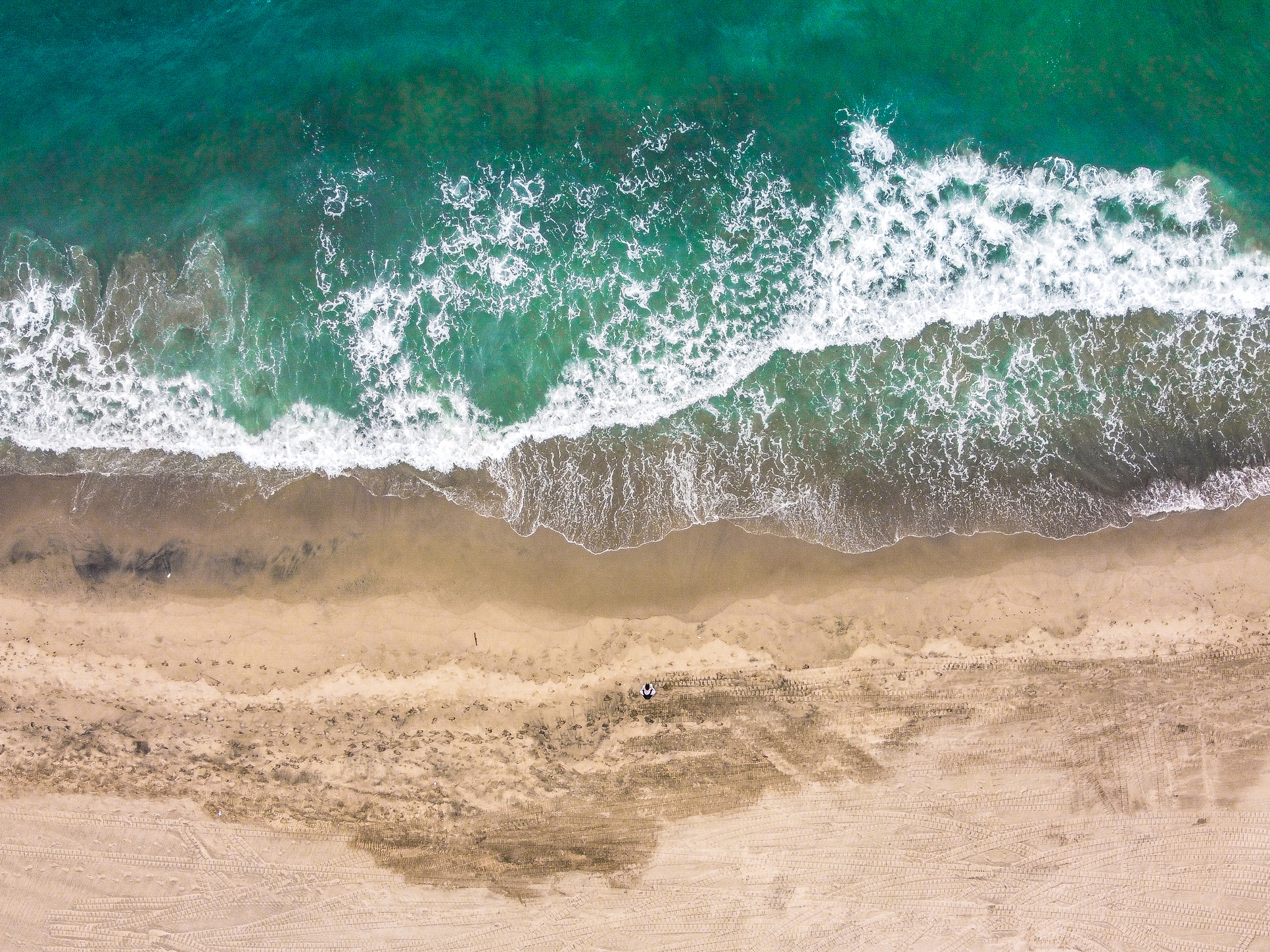 Foamy sea near sandy beach in summer